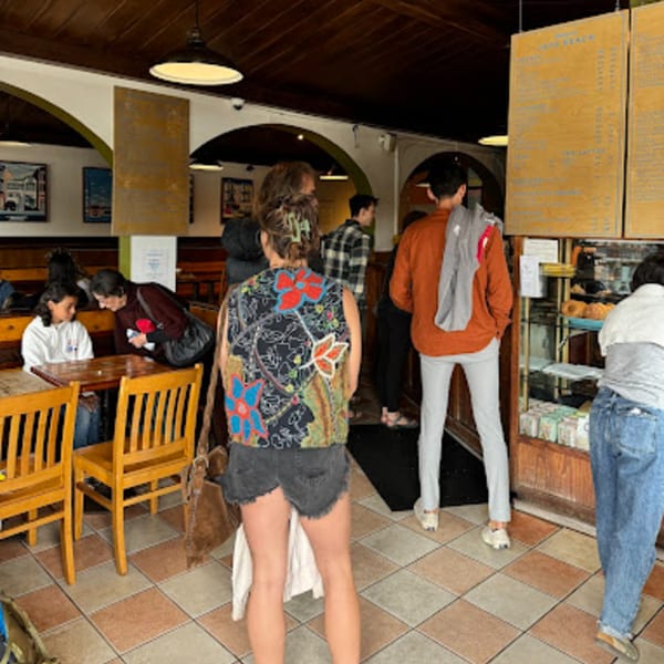 Customers ordering and dining inside Java Beach cafe, with menus and pastries visible.