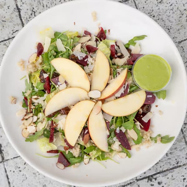Java Beach's colorful salad with apple slices, greens, beets, nuts, and a side of green dressing.